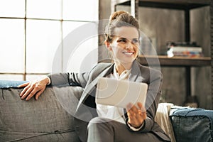 Happy business woman sitting on divan in loft