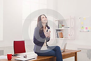 Business woman sitting on wooden desk at office