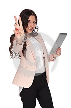 Happy business woman with tablet makes victory sign