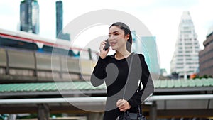 Happy business woman talking with mobile phone in city
