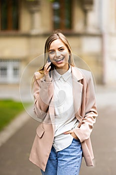 Happy business woman talking on phone on the street