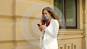 Happy business woman texting mobile phone outdoors. Smiling businesswoman