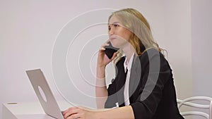 Happy business woman using mobile phone for business conversation in office