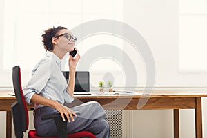 Happy business woman at work talking on phone