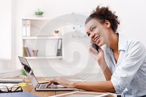 Happy business woman at work talking on phone
