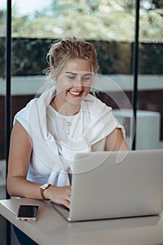 Happy business woman working laptop computer at coffee shop interior, internet distance work