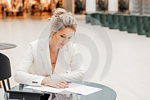 Happy business woman working in office with documents. business woman in a business suit works at the table with documents