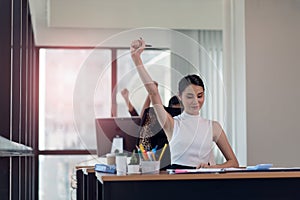 Happy business woman working in the office with your hands up