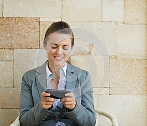 Happy business woman writing text message