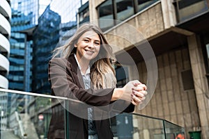 Happy business women portrait of young female urban professional businesswoman in suit standing outside office building cross-