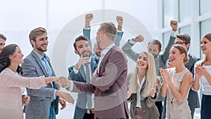 Happy businessman accepting congratulations of his colleagues