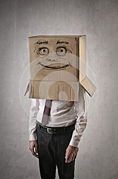 Happy businessman with a box on his head