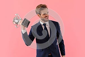 Happy businessman celebrating with his trophy and shouting