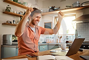 Happy, businessman celebrating and with laptop for remote work in kitchen of his home. Success or achievement