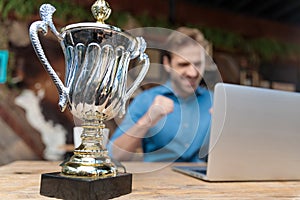 Happy businessman celebrating and working on his laptop