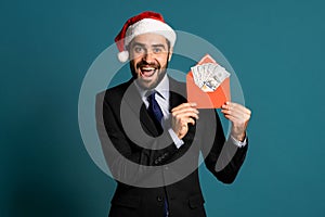 Happy businessman in corporate suit with tie holding dollars money in envelope