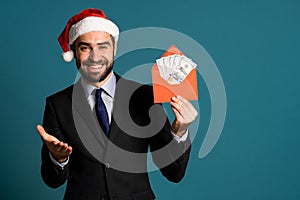 Happy businessman in corporate suit with tie holding dollars money in envelope
