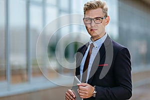 Happy businessman with digital tablet. Portrait of a Male executive manager in trendy clothes with tablet PC in hand on