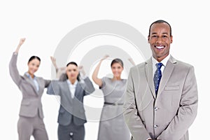 Happy businessman with enthusiastic co-workers in the background