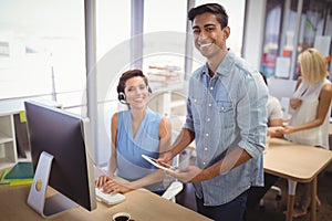 Happy businessman and female customer service representative working in office