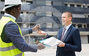 Happy businessman gets the keys to new shopping center