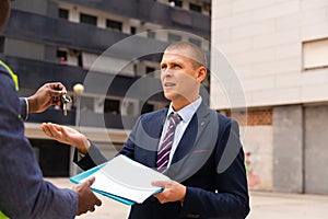 Happy businessman gets the keys to new shopping center