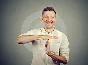 Happy businessman giving time out hand gesture