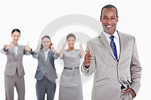 Happy businessman with a hand in his pocket approving with co-workers photo