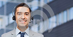 Happy businessman in headset over business center