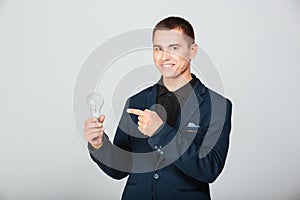 Happy businessman holding bulb