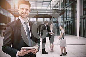 Happy businessman holding digital tablet