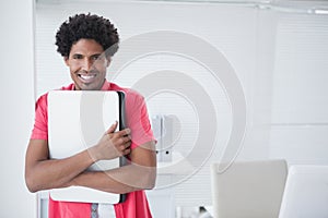 Happy businessman holding his laptop