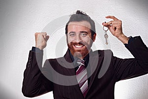 Happy businessman holding a house key