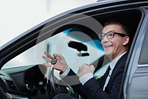 Happy businessman holding keys to his new car