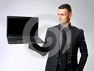 Happy businessman holding laptop