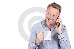 Happy businessman holding morning mug tea and speaking phone