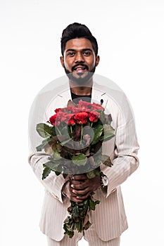 Happy businessman holding roses flowers bouquet over white background. Looking at camera