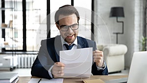 Happy businessman learning good news, reading letter, getting document