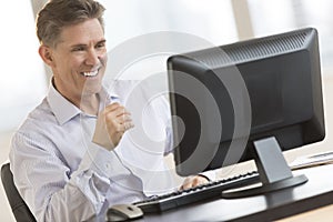 Happy Businessman Looking At Computer Monitor photo
