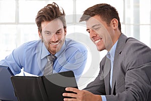 Happy businessman looking at personal organizer