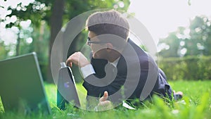Happy businessman lying on grass and relaxing after hardworking, inner harmony