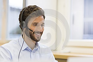 Happy Businessman in the office on the phone, headset, Skype