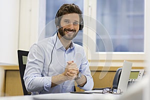 Happy Businessman in the office on the phone, headset, Skype