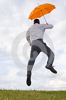 Happy businessman with orange umbrella