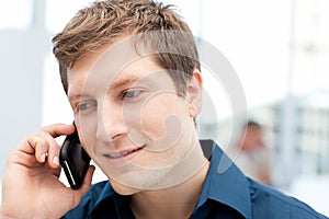 Happy businessman phoning in his office