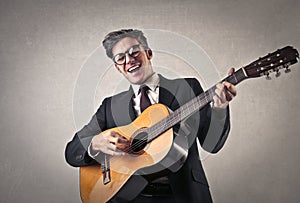 Happy businessman playing the guitar