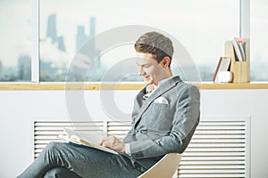 Happy businessman reading book