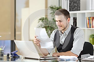 Happy businessman reading a letter at office