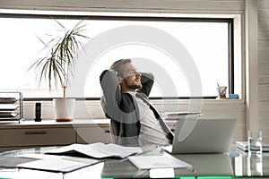 Happy businessman relax in chair in office