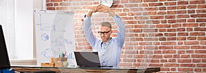 Happy Businessman Relaxing On Fitness Ball In Office